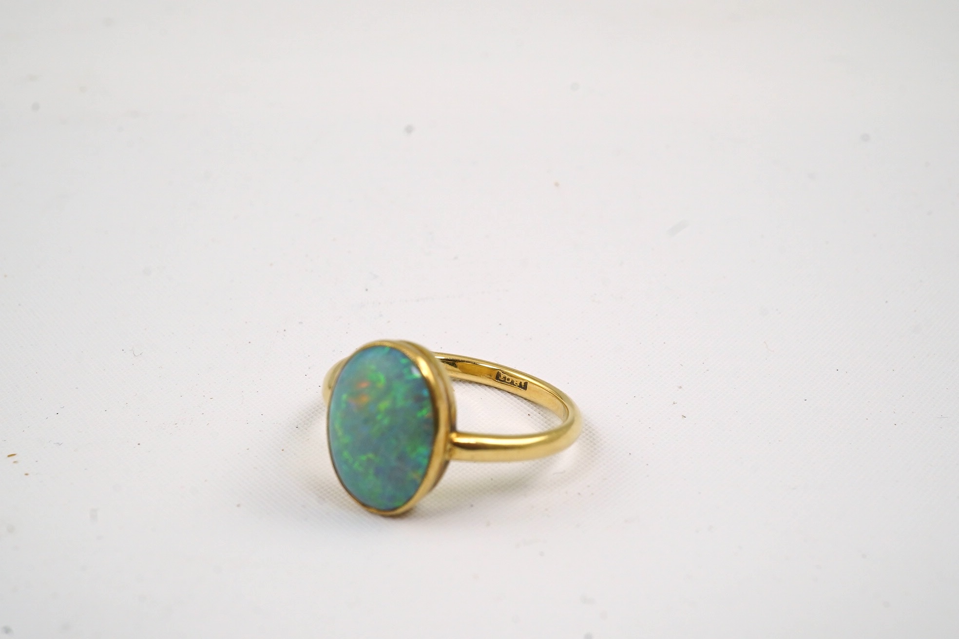 An 18ct gold and single stone oval cabochon opal set ring